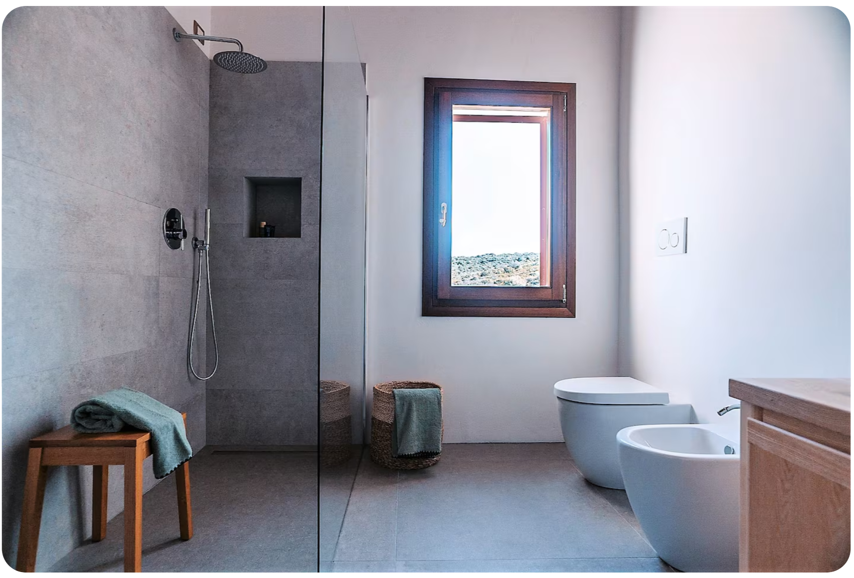 Modern grey bathroom with walk-in rain shower and countryside view