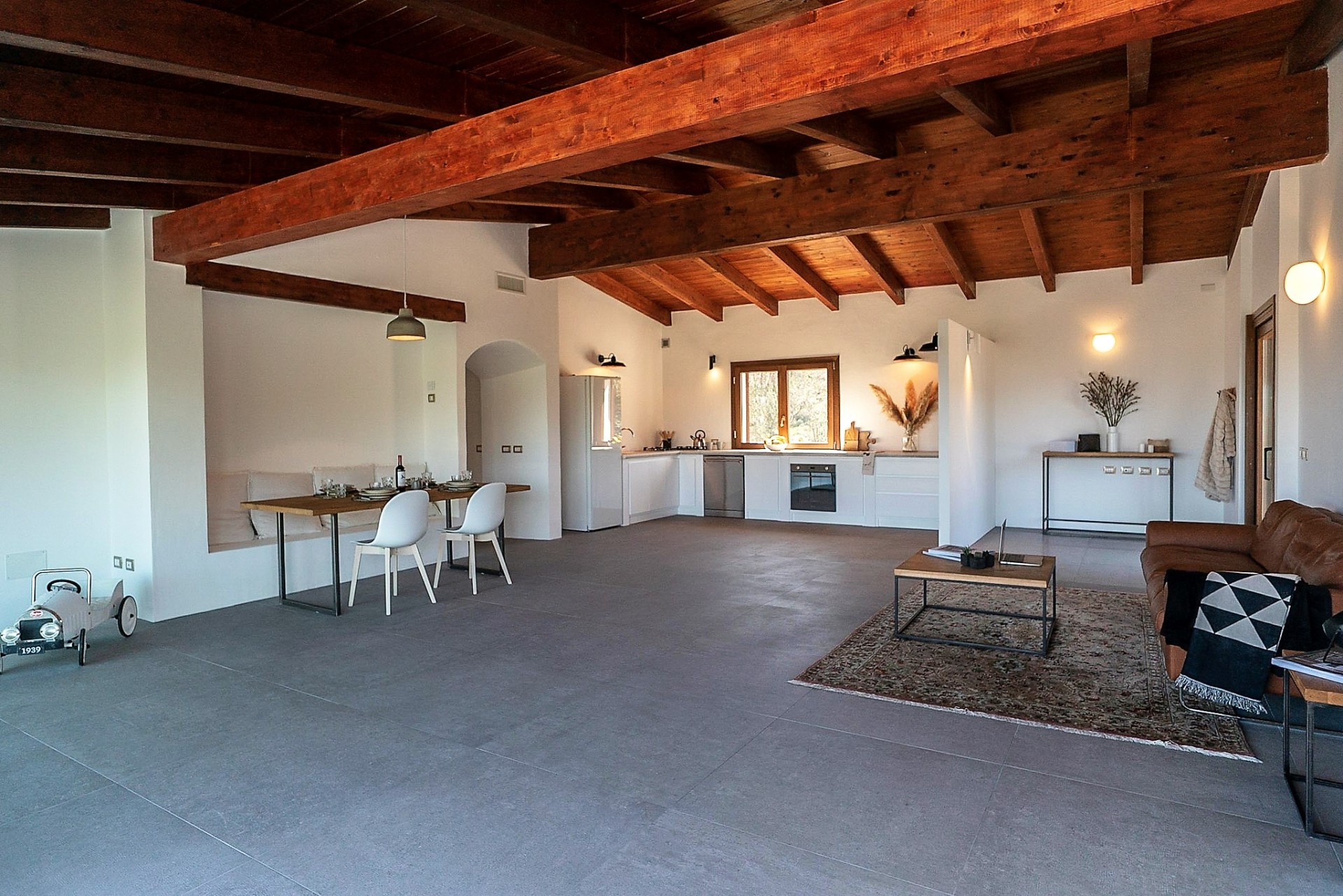 Open-plan living and kitchen under exposed wooden beams