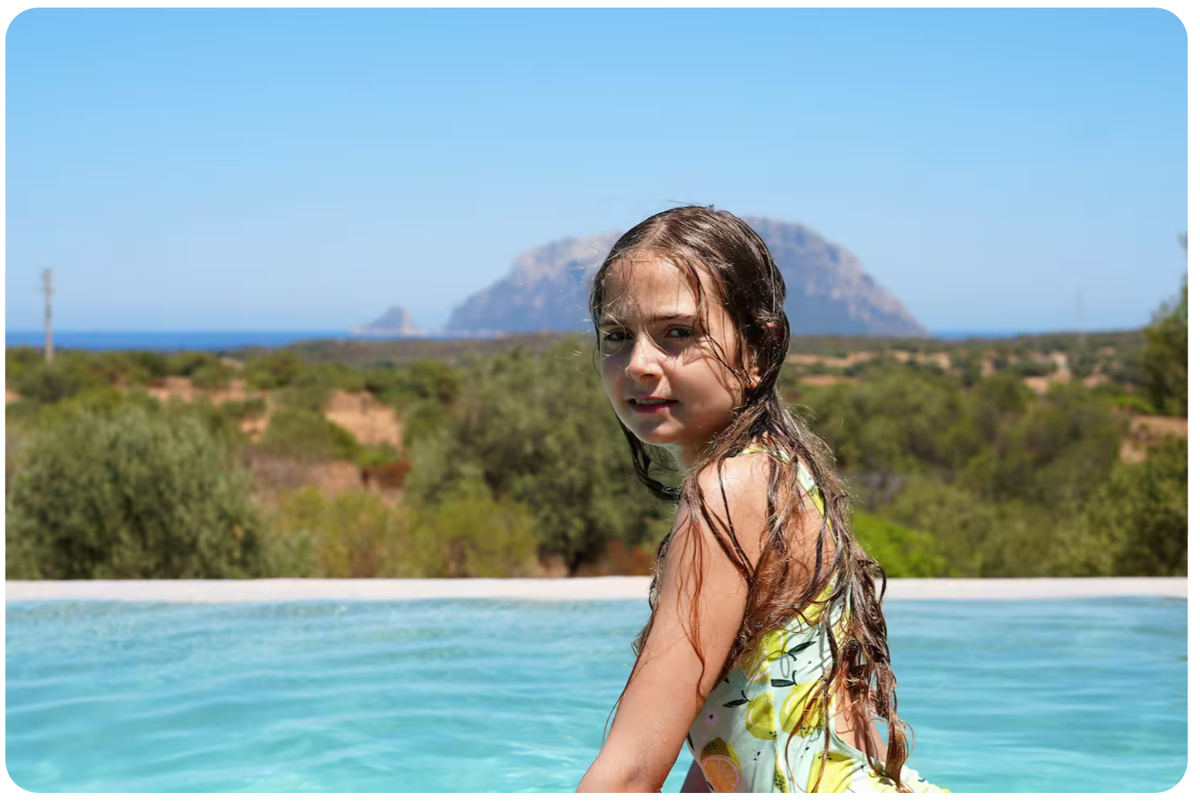 Child in the pool with Tavolara island in the distance