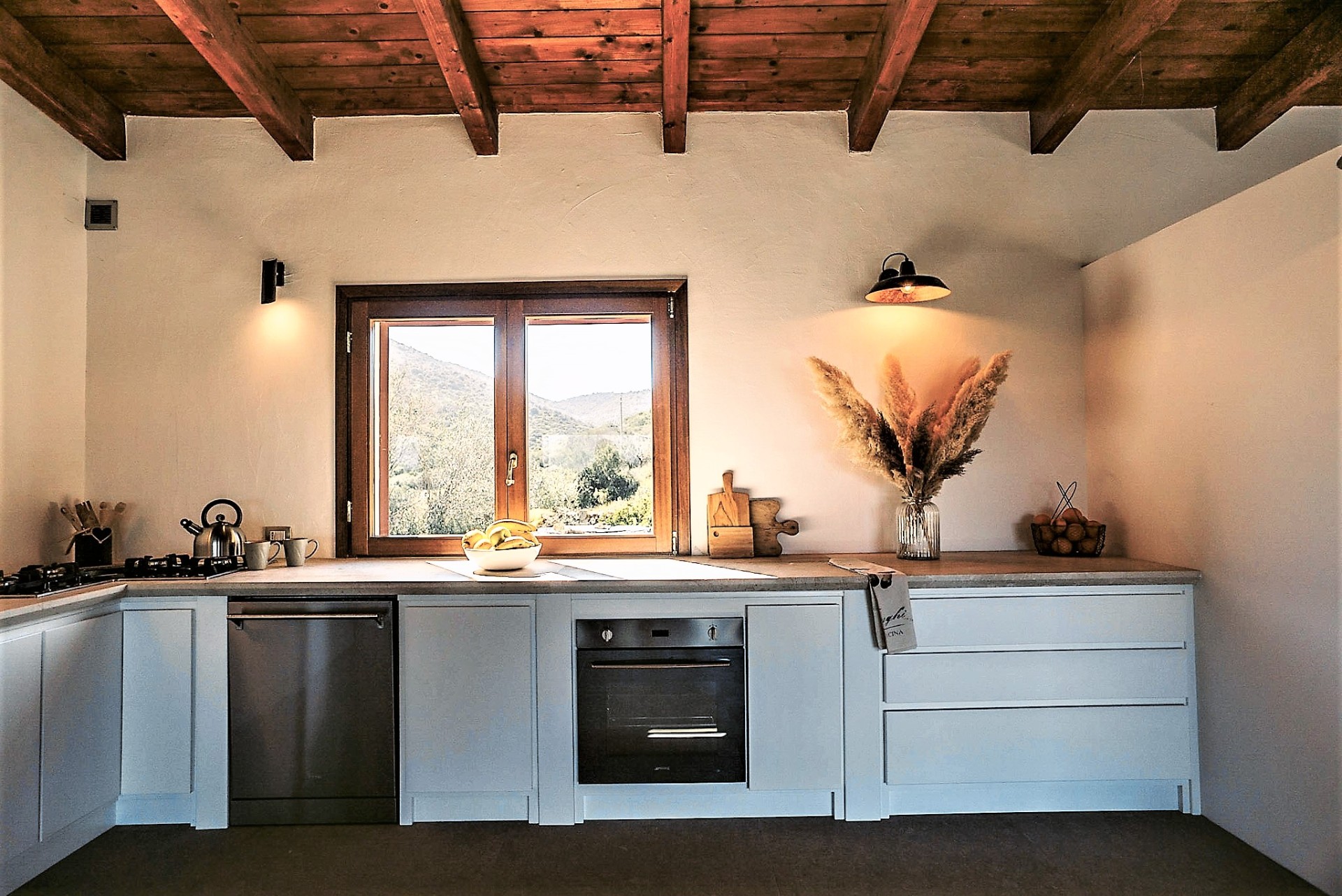 Kitchen with hillside view through a wooden window
