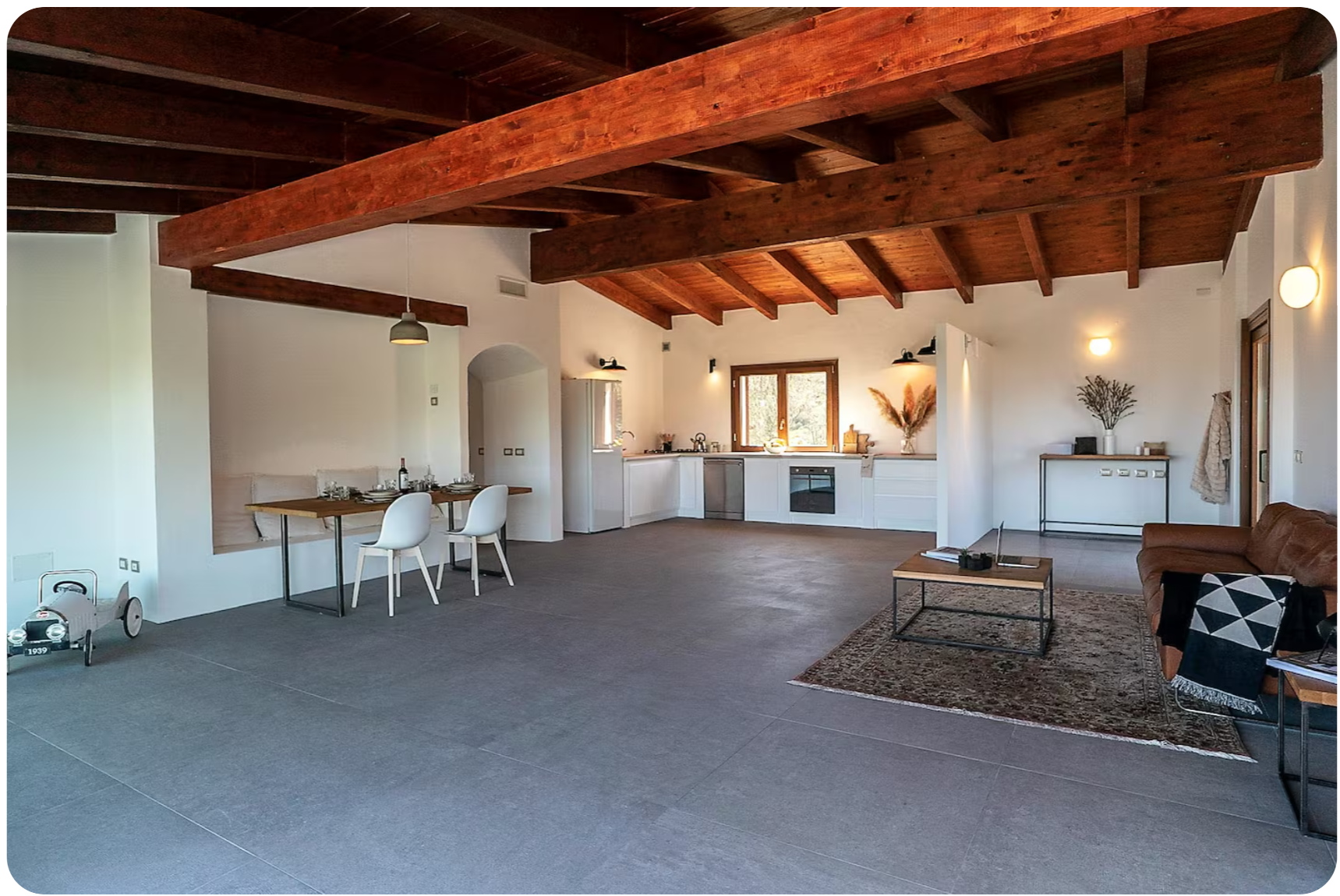 Open-plan living room and kitchen under wooden beams