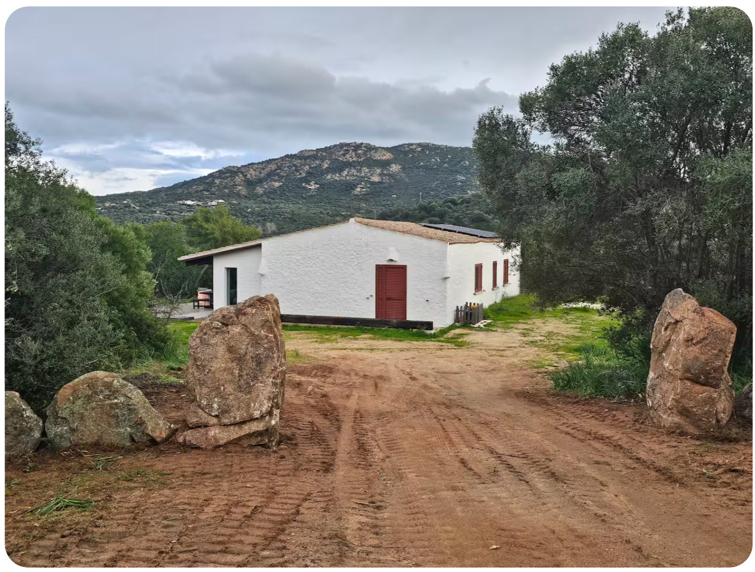 Arrival view of the villa set among granite rocks and hills