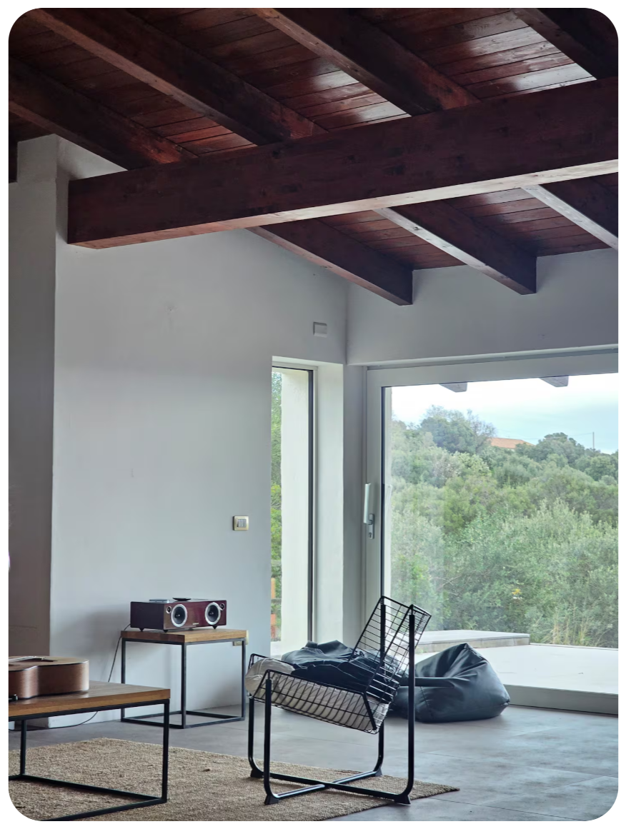 Lounge corner with floor-to-ceiling window looking into the olive trees