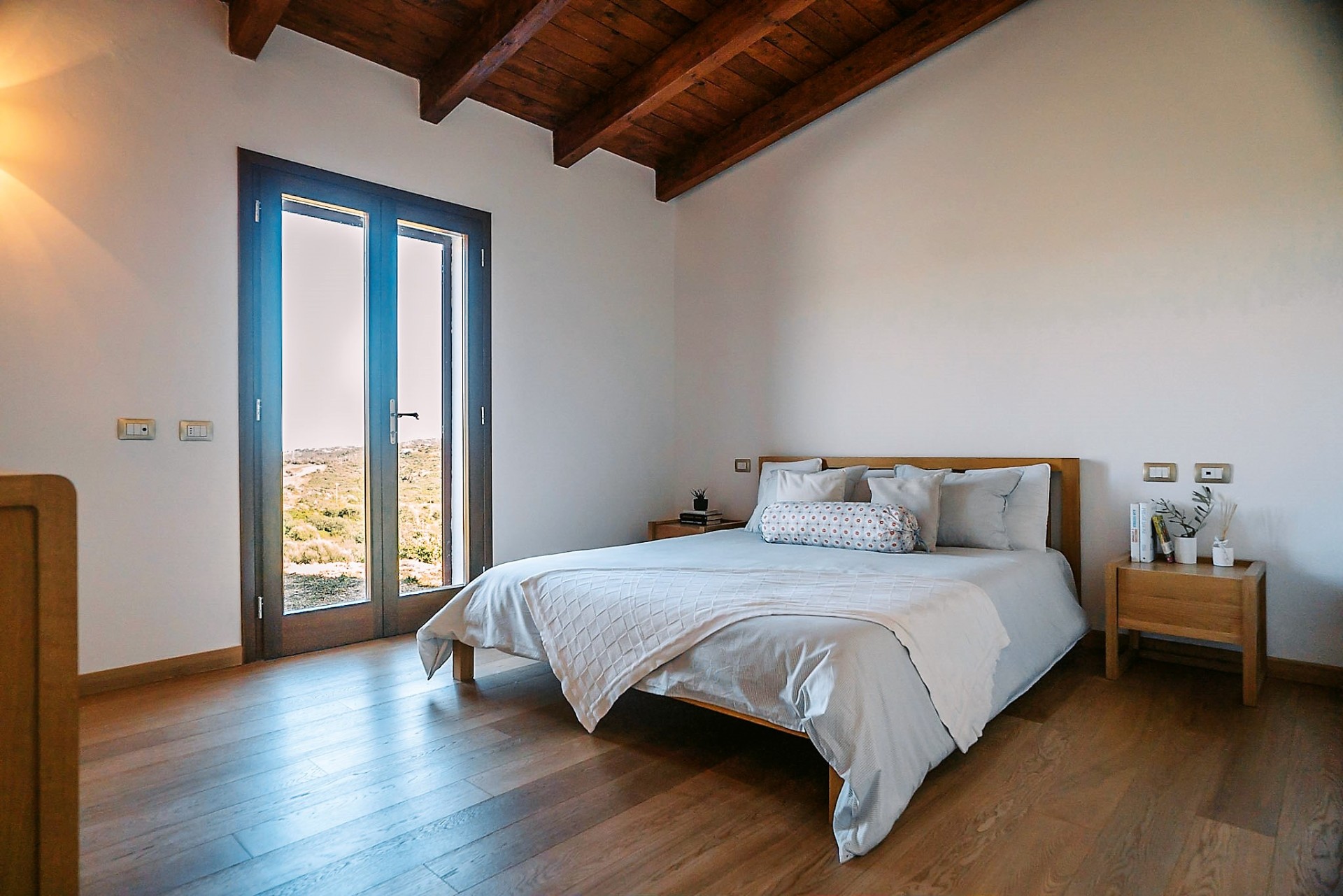 Bedroom with french doors opening to the Sardinian landscape