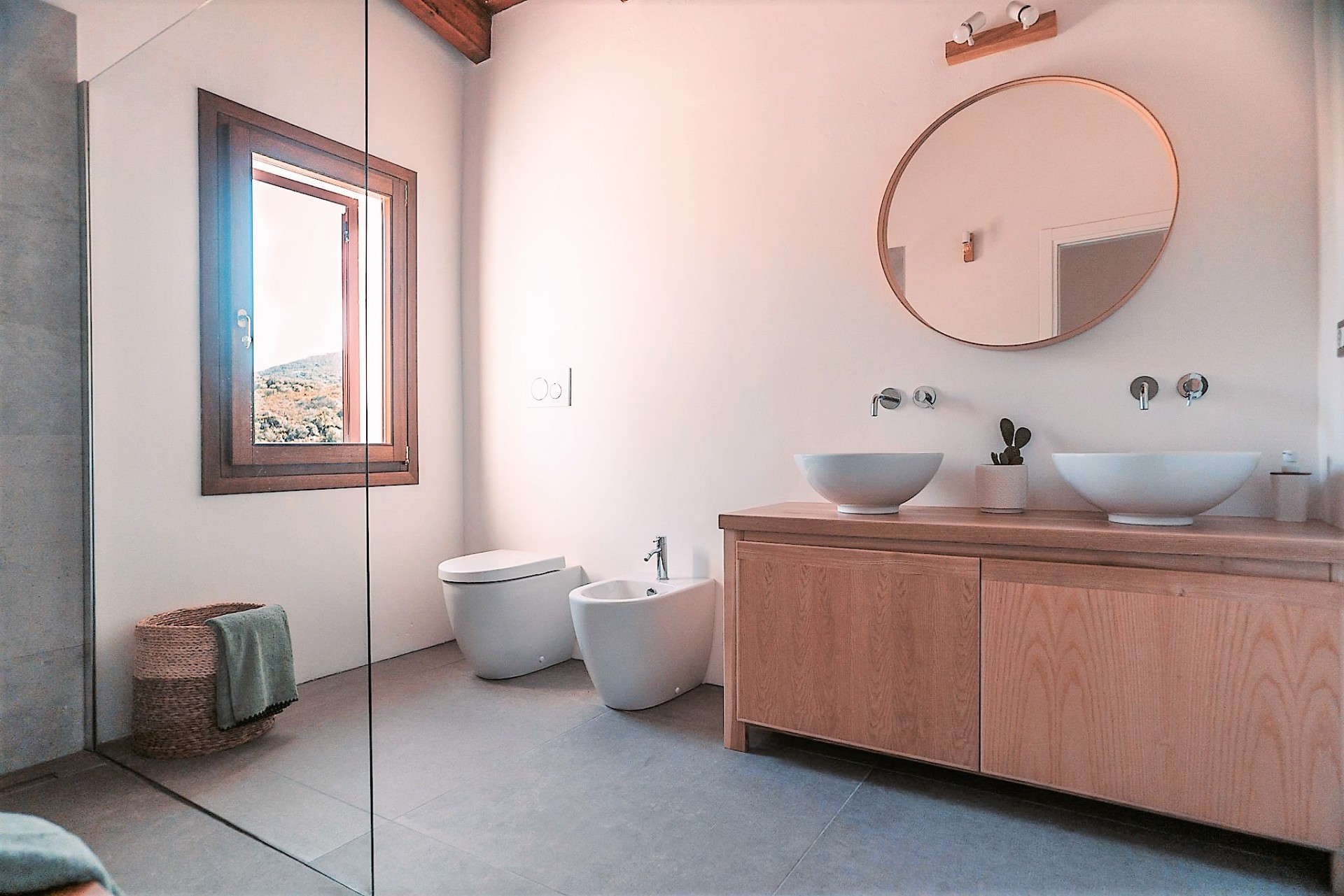 Second bathroom with double vessel sinks and round mirror